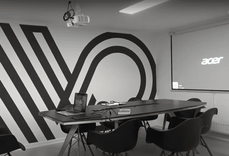 Conference room with Virtoffice logo, black table, and projector.